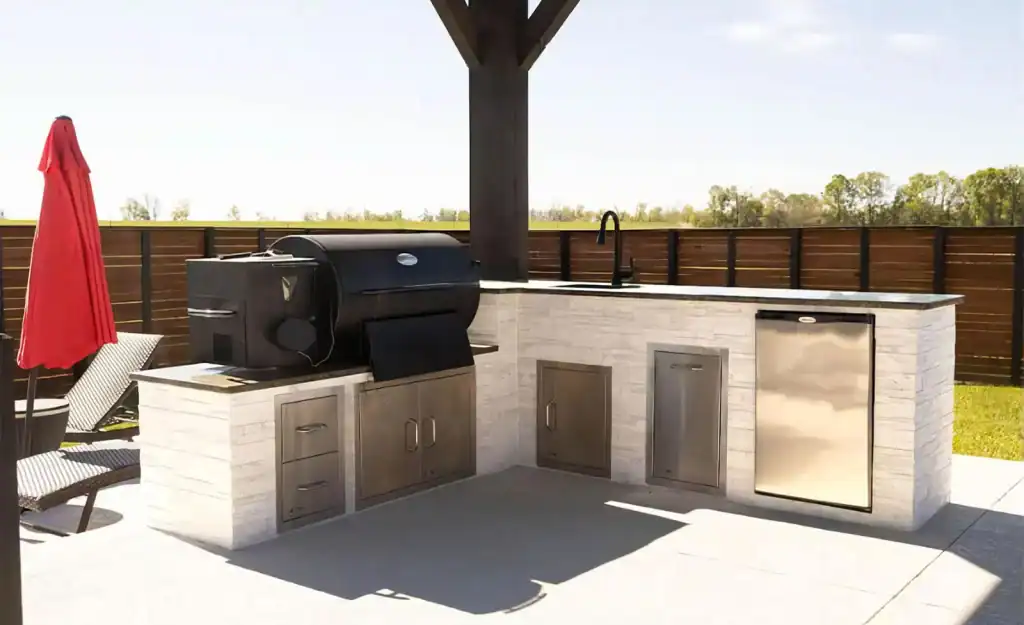 Premium outdoor kitchen with built-in grill, stainless steel appliances, and granite countertops for backyard entertaining and poolside dining.