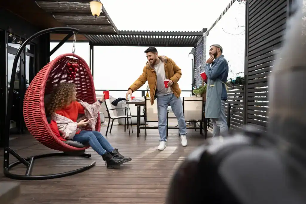 Relaxed outdoor gathering on a stylish rooftop patio during winter, featuring friends with holiday drinks, cozy seating, and festive decorations, creating a warm and inviting atmosphere.