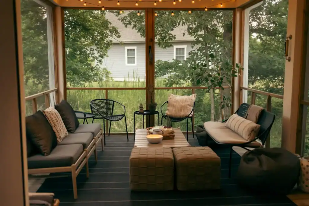 Bright screened porch with comfortable seating, cozy pillows, and lush greenery outside, perfect for relaxing and entertaining in style.