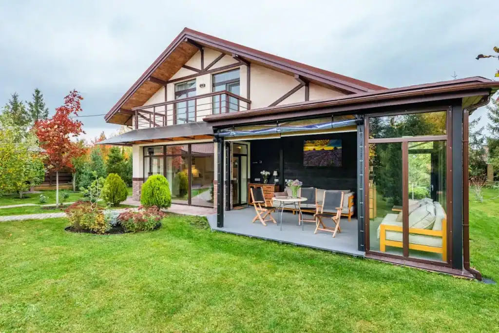 Elegant home with a spacious screened porch, modern decor, and lush landscaping, ideal for relaxing and entertaining outdoors.