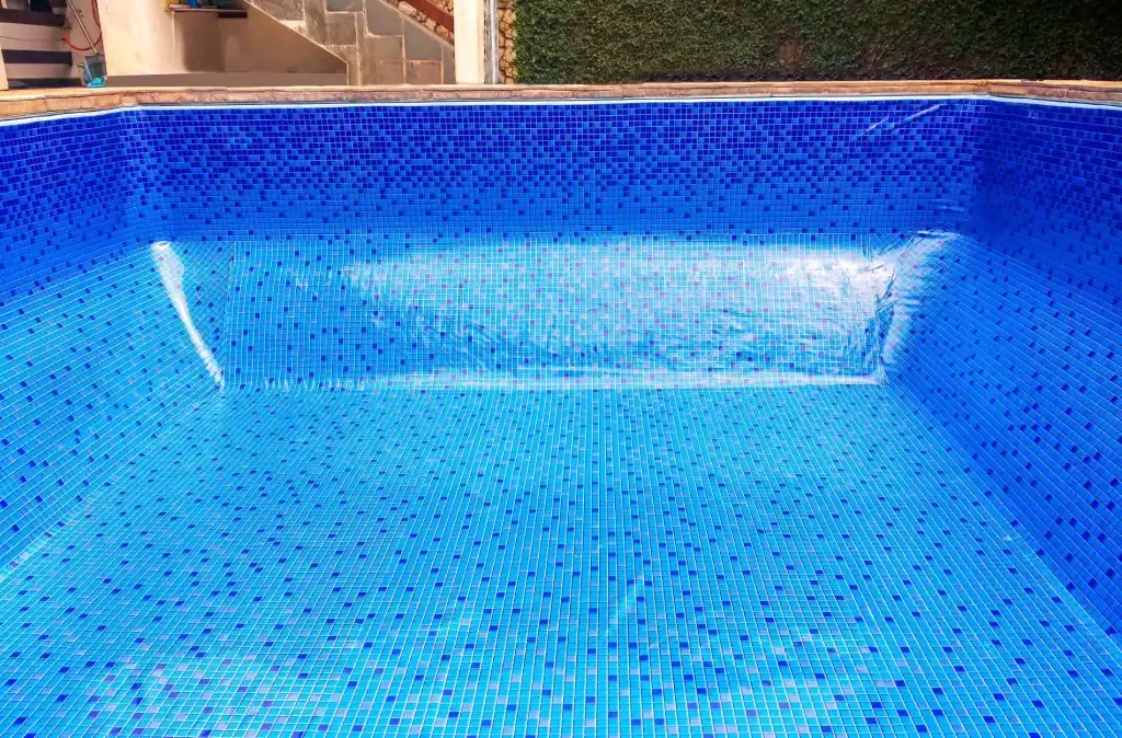 Bright blue tiled in-ground swimming pool with a modern design, perfect for backyard leisure and relaxation. Constructed with durable materials, providing a stunning centerpiece for outdoor living spaces.