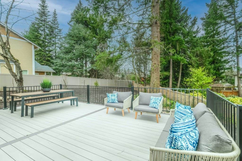 Bright outdoor patio with modern furniture and surrounding greenery for relaxing poolside.