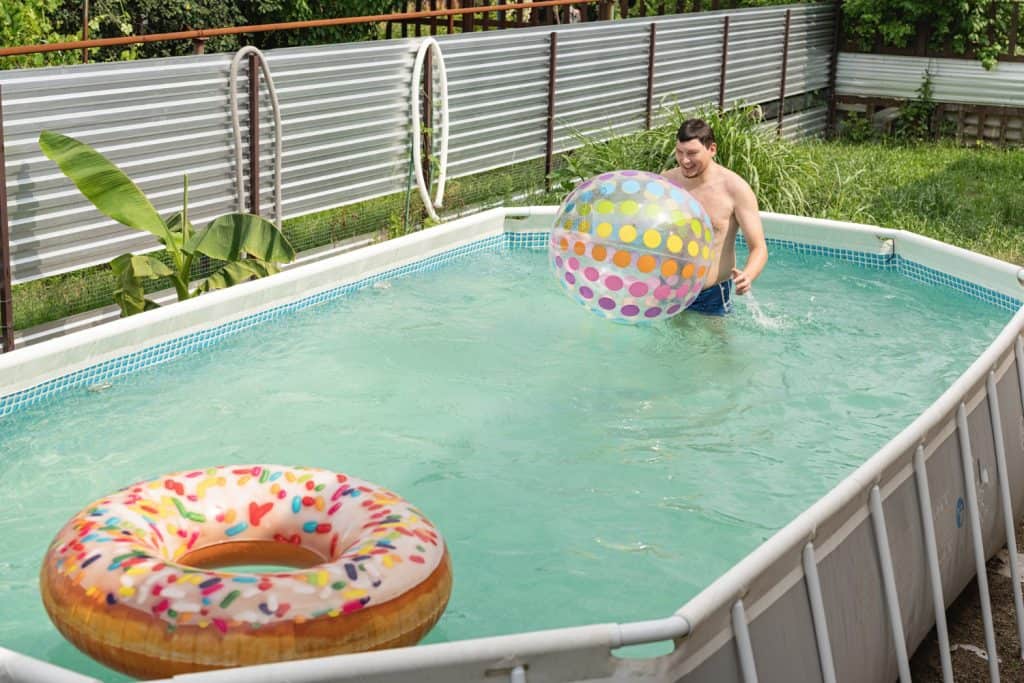 Enjoy a refreshing swim in this above ground pool featuring a vibrant beach ball and donut float, perfect for backyard entertainment in Baton Rouge.