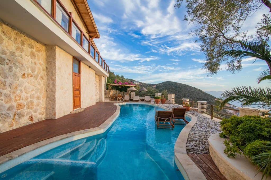 An elegant backyard pool featuring a modern design, surrounded by lush greenery and scenic mountain views, perfect for relaxing and entertaining.