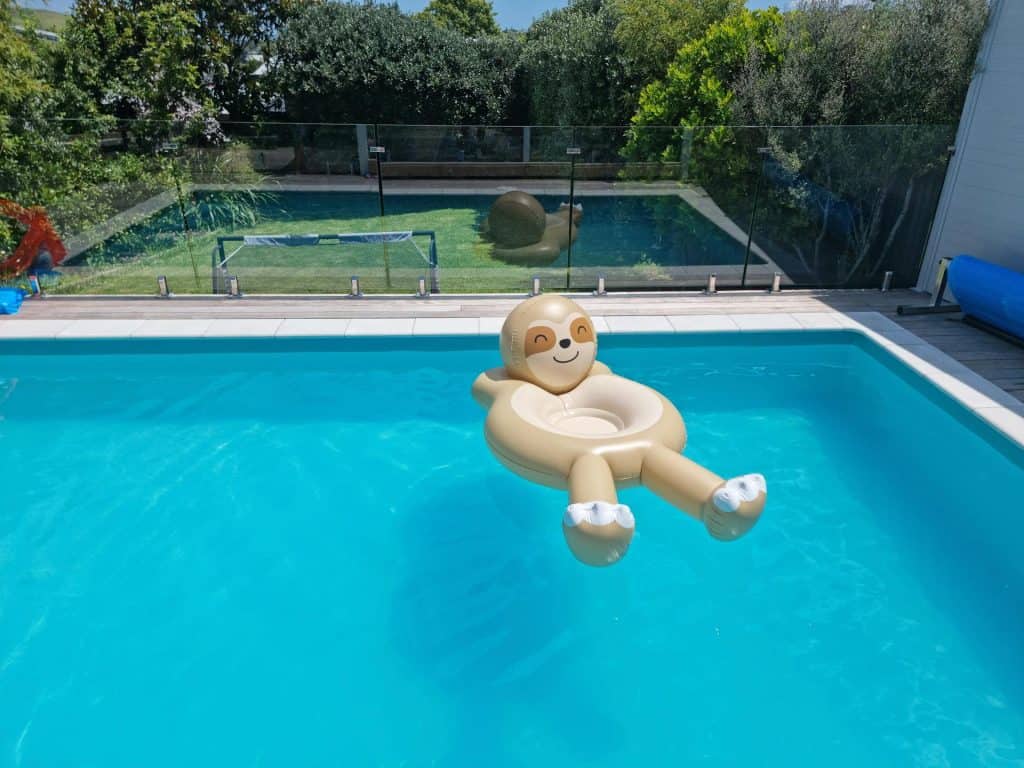 Bright blue swimming pool featuring a cute monkey float in Baton Rouge. Perfect for family fun and relaxing outdoors during spring and summer seasons.