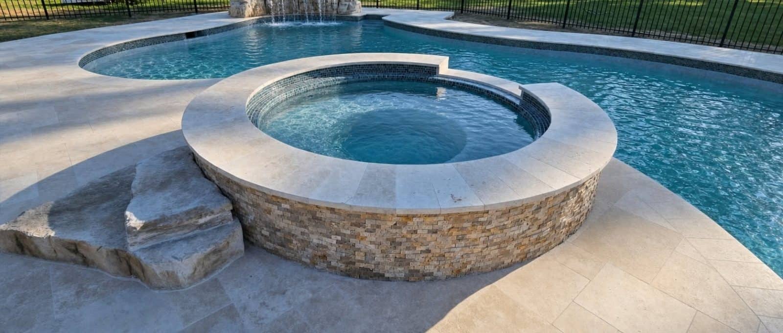 Freeform gunite pool with raised stacked-stone spa and rock waterfall in Baton Rouge