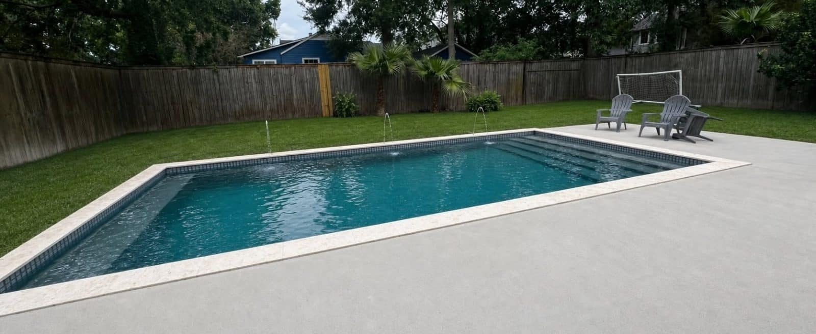 Rectangular gunite pool with tanning ledge and deck jets in a fenced Baton Rouge backyard